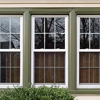 Green-framed windows outside home