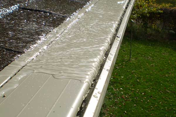 Close up of water running into a white LeafX gutter guard