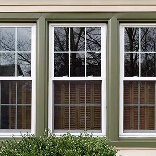 Green-framed windows outside home